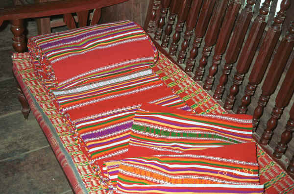 Jpeg 47K A roll of weaving for cutting into bag lengths and cushion and mattress ends, Black Thai village, Dien Bien Phu, Lai Chau Provine.  Note the cushion edge using similar weaving just showing which has been covered by a protective raffia mat. 9510D02.JPG