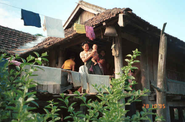 Jpeg 32K Black Thai family coming out to say good bye - the baby is shown in the baby carrier in the Photo gallery to the left above this thumbnail and the woman's blouse shown further above was in the process of being sewn when we came along.  Dien Bien Phu, Lai Chau Province. 9510E28.JPG