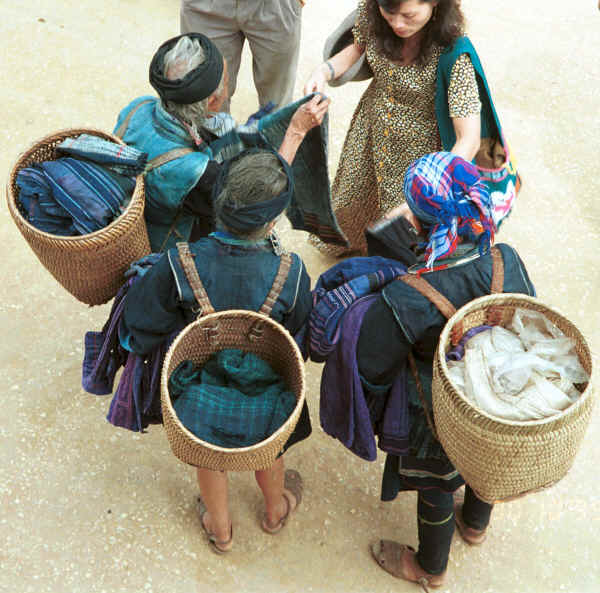 Jpeg 49K Black Hmong women trading old clothing with western tourists in the streets of Sa Pa, Lao Cai Province.  Some of the clothing has been over-dyed with turquoise or purple chemical dyes. 9510H34.JPG