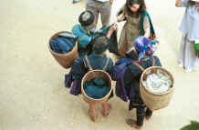 to Jpeg 49K Black Hmong women trading old clothing with western tourists in the streets of Sa Pa, Lao Cai Province.  Some of the clothing has been over-dyed with turquoise or purple chemical dyes. 9510H34.JPG