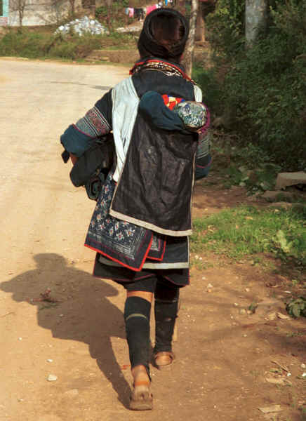 Jpeg 31K Black Hmong Woman carrying her baby home from Sa Pa, Lao Cai Province in an embroidered and batiked baby carrier  9510I23.JPG