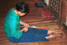 to Jpeg 44K 9511A02 Weaving a braid with the warp tension achieved between toes and a tie around the waist. Although the braid is narrow quite a complicated shed is set up. Luong village on the road from Sa Pa to Lao Cai town, Lao Cai province.