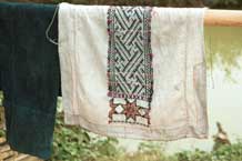 to Jpeg 37K 9511A10 Dao Quan Trang woman's bodice hanging out to dry and showing the reverse side of the embroidery with the characteristic stars at the base. The background fabric is probably cottton. Luong village on the road from Sa Pa to Lao Cai town, Lao Cai province. 