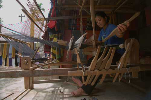 Jpeg 31K mc4 Thu weaves fabric on the loom beneath her house which she shares with all the women in her family. The Mai Chau valley, Hoa Binh Province, northern Viet Nam.